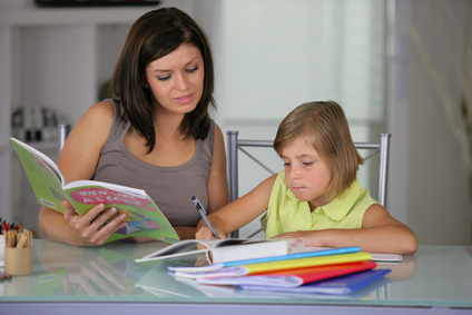 Portrait d'une femme aidant une petite fille à faire ses devoir